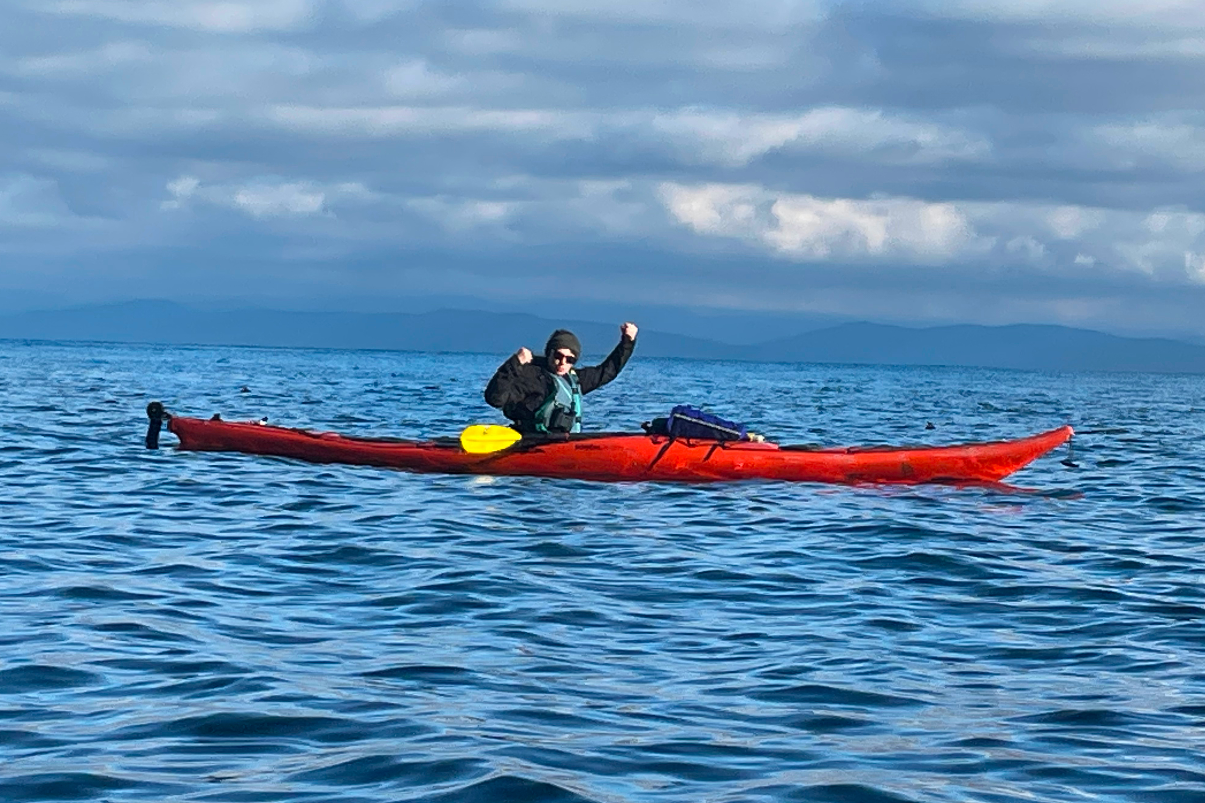 Woman paddling sea kayak offshore