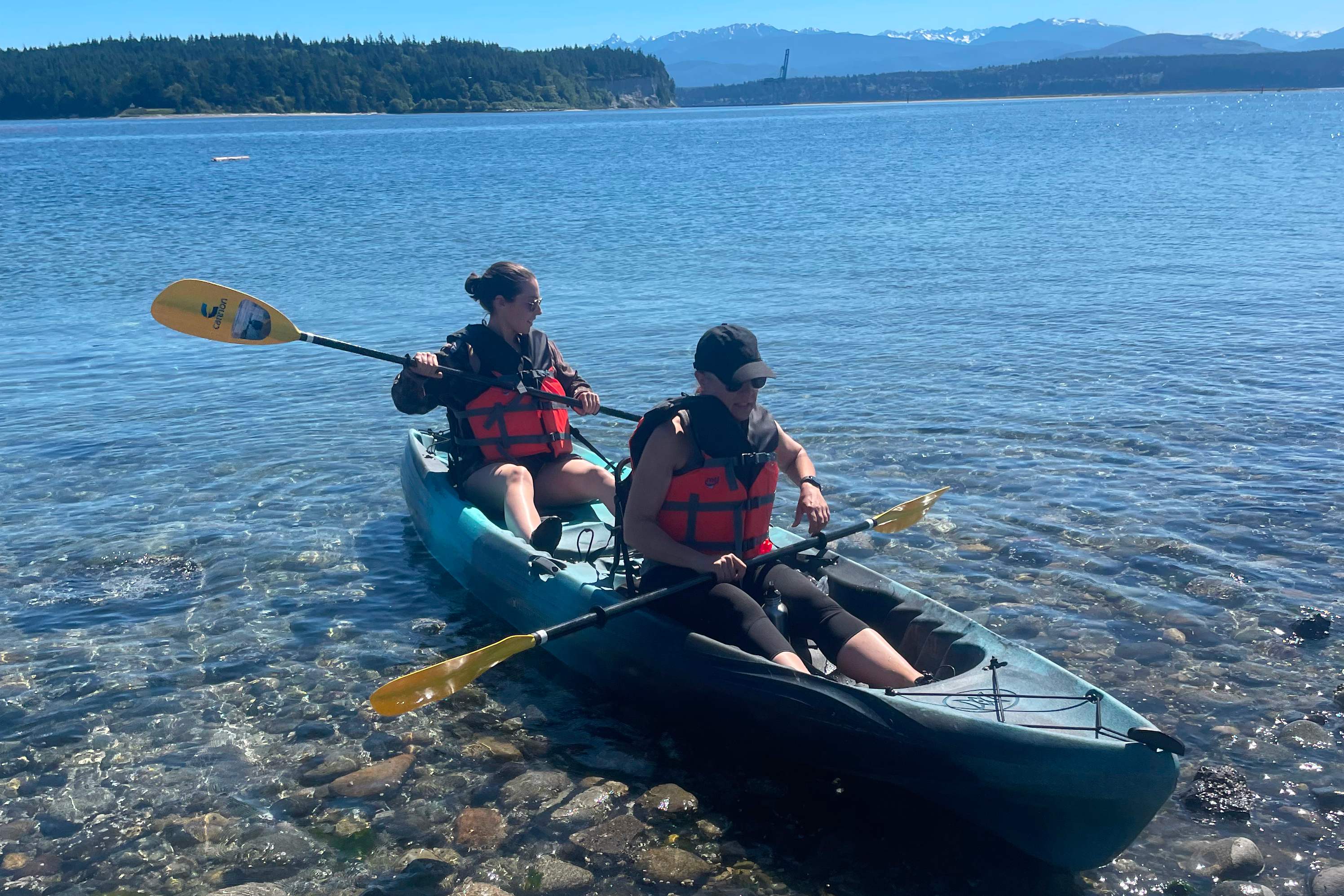 Two people paddle double sit-on-top kayak