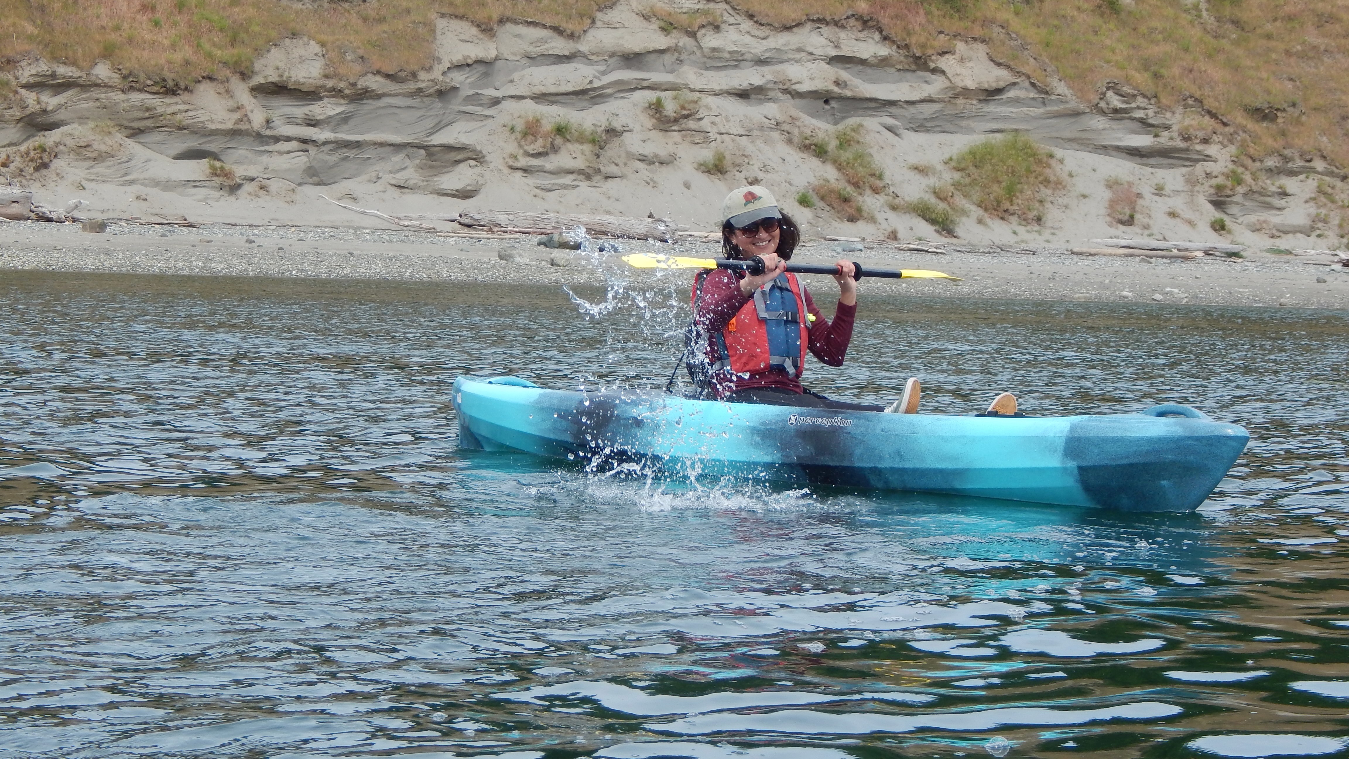 Woman paddles single sit-on-top kayak